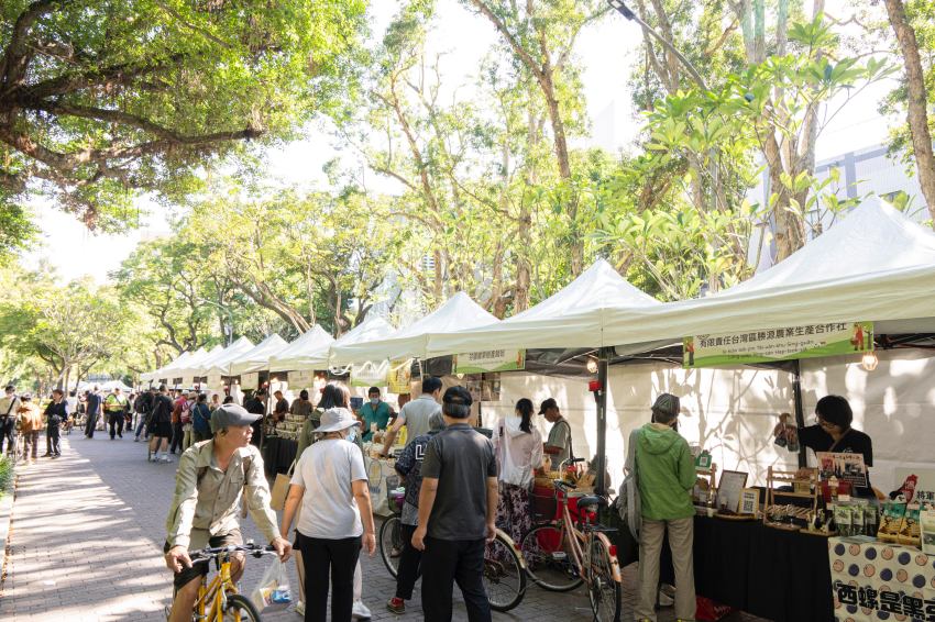 臺大USR農夫市集在臺大舟山路林蔭下舉行,白色帳篷綿延,吸引許多民眾與師生前來逛市集。