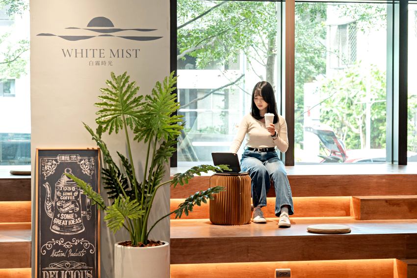 陽光灑落的階梯座位區,結合品牌白霧時光旗艦店視覺與植栽營造休閒氛圍