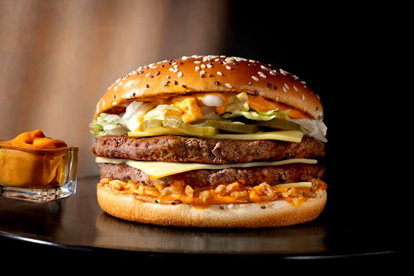 Big Arch霸牛堡近距離特寫，可見芝麻奇亞籽麵包夾著層次分明的四盎司牛肉與白切達吉事。