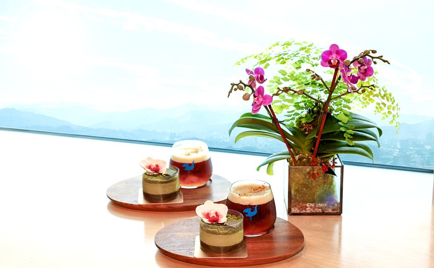 台北101攜手kafeD推出觀景台限定新品,包含金桂愛玉耶加雪菲與擂茶巧克力蘭花蛋糕,讓遊客佐以高空美景享受味覺療癒。