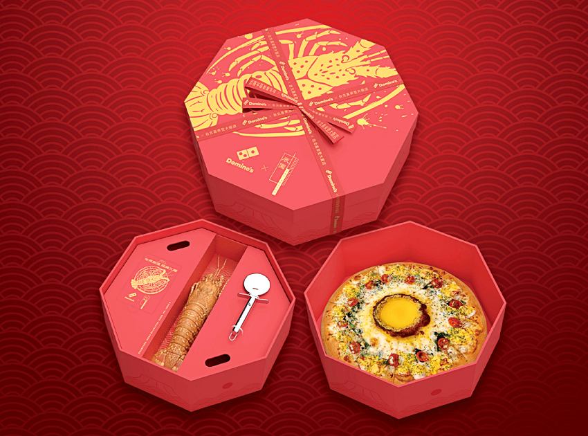 達美樂與台北喜來登辰園聯名推出的限量禮盒，內含整隻加勒比海龍蝦與專屬披薩刀，展現頂級年菜氣勢 。