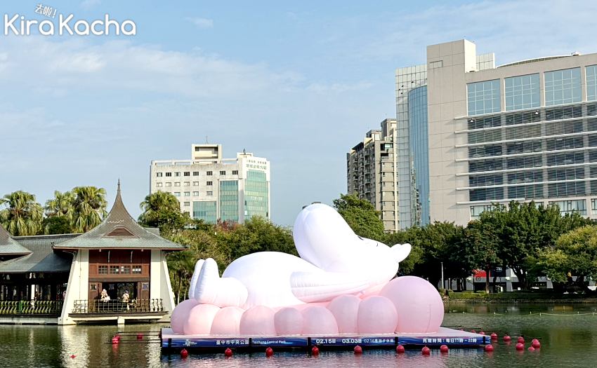 巨型姆明Moomin（嚕嚕米）裝置慵懶地躺在粉紅雲朵上，與後方的台中市區建築形成有趣的對比，展現城市中的悠閒氛圍。