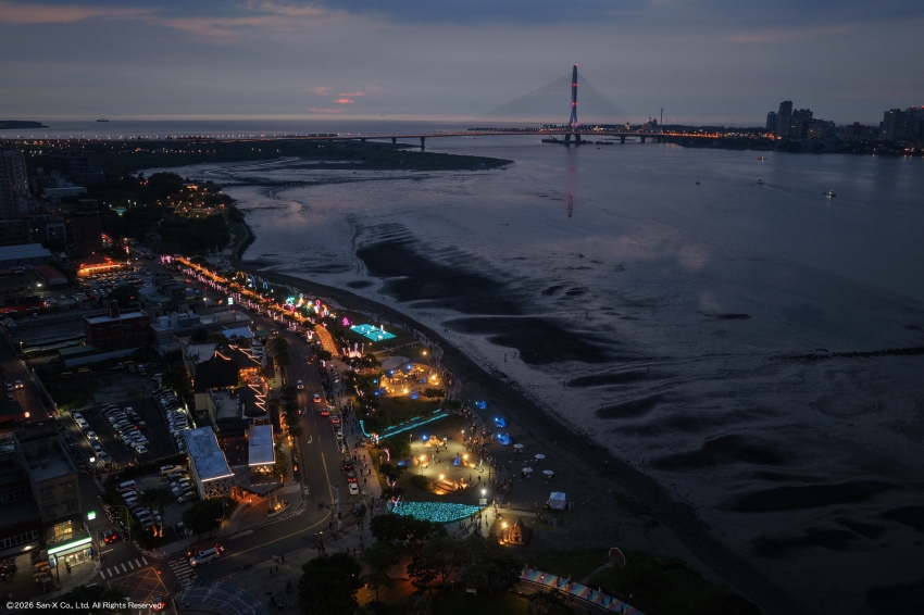 淡水河岸夜色與沿岸燈光呈現八里城市沙雕展夜間景觀。圖/新北市政府高灘地工程管理處提供